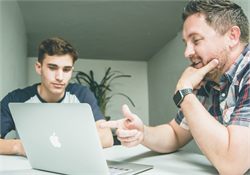 Two people discussing a project over a laptop