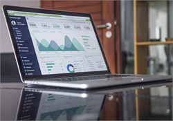 A laptop displaying a web analytics dashboard with charts